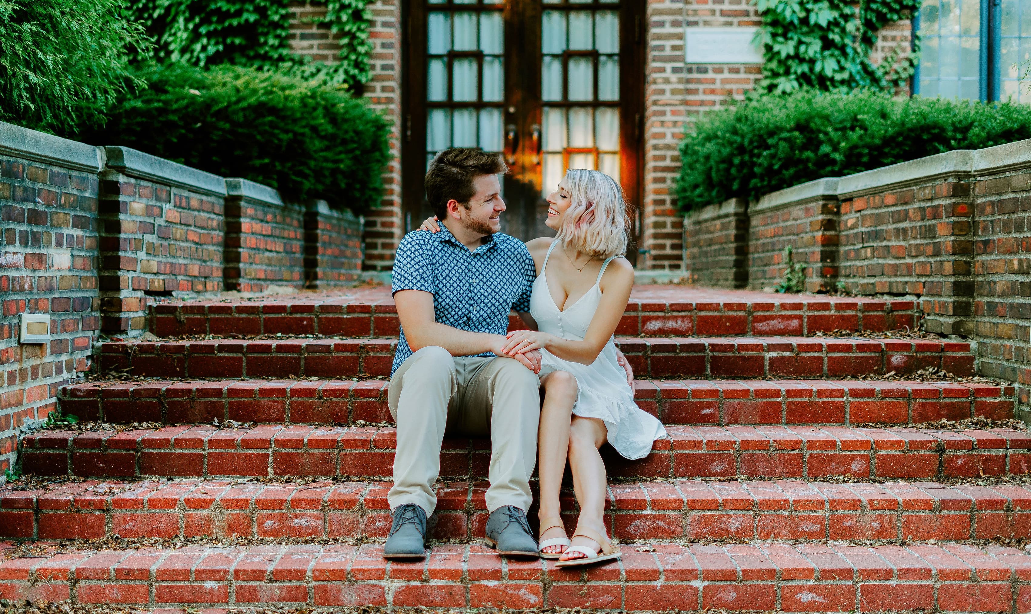 Makayla and Drew sitting together outside on a flight of brick stairs.